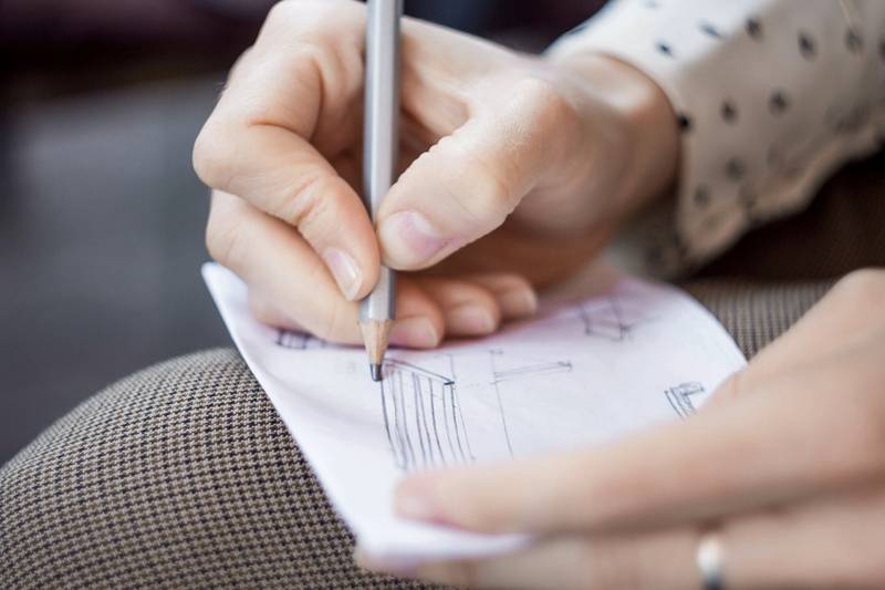 Manos con un lápiz sobre un papel con un plano