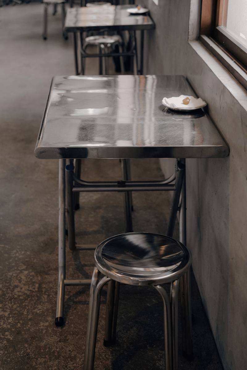 Mesa de acero y un taburete junto a una ventana