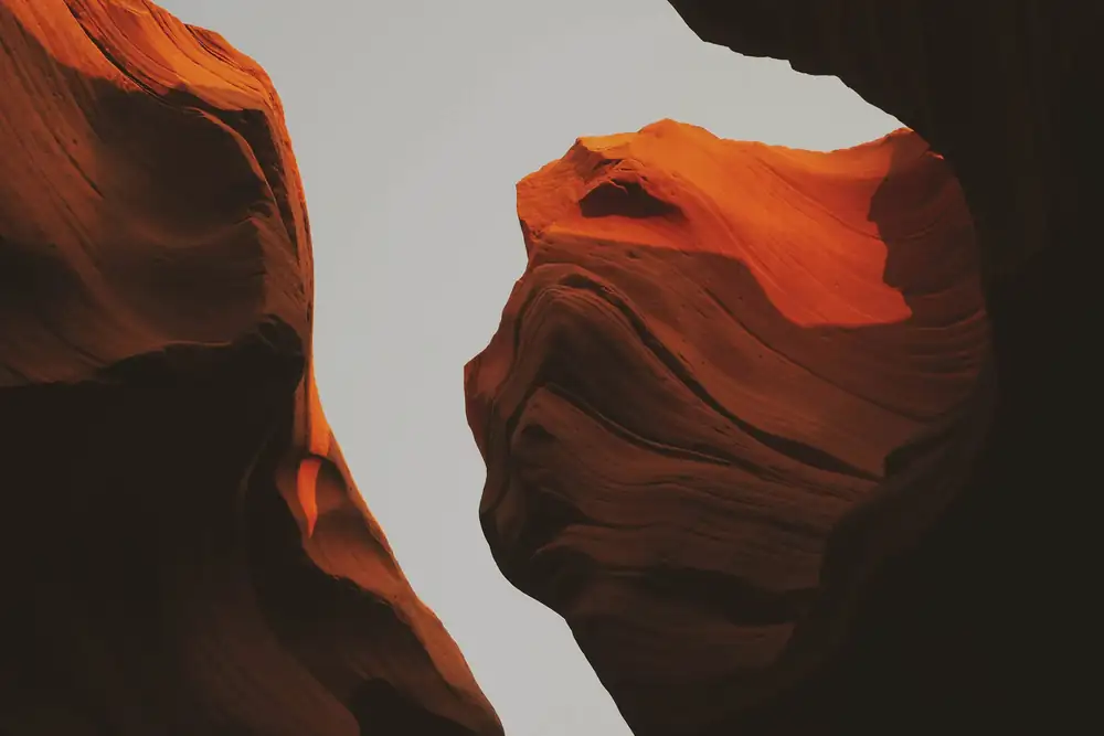 Paredes de un cañón rojo con una grieta de cielo gris