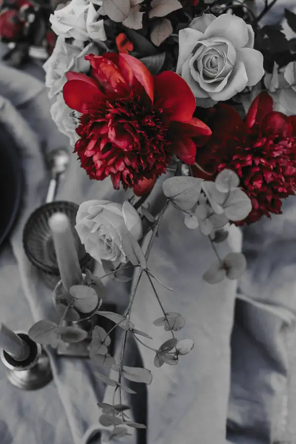 Flores rojas y crema sobre un mantel gris azulado