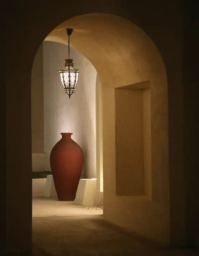 Vasija roja en un arco iluminado por una lámpara colgante