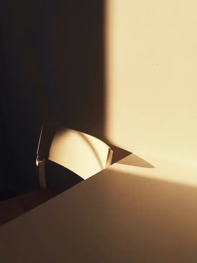 Papel plegado en una esquina, entre luz tibia y sombra