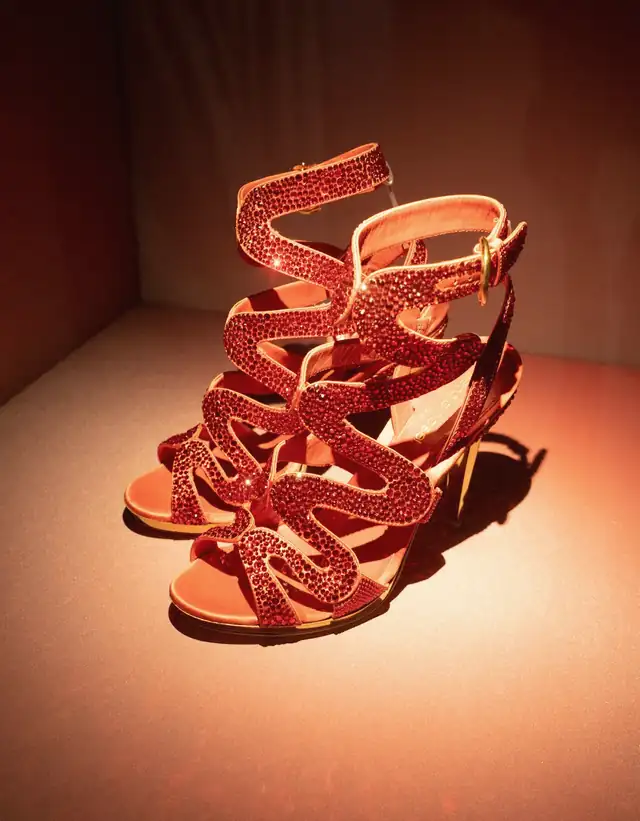 Sandalias rojas de tiras sobre una caja iluminada en rojo