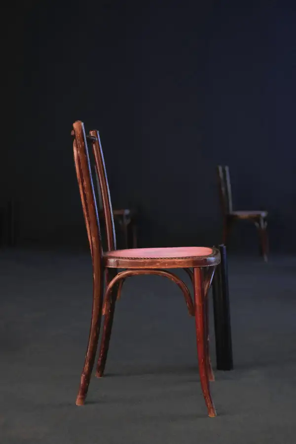 Silla de madera torneada sobre un suelo oscuro