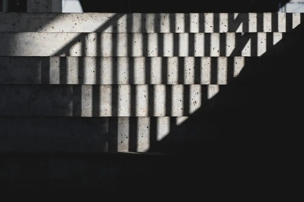 Escalones de hormigón con franjas de luz y sombra