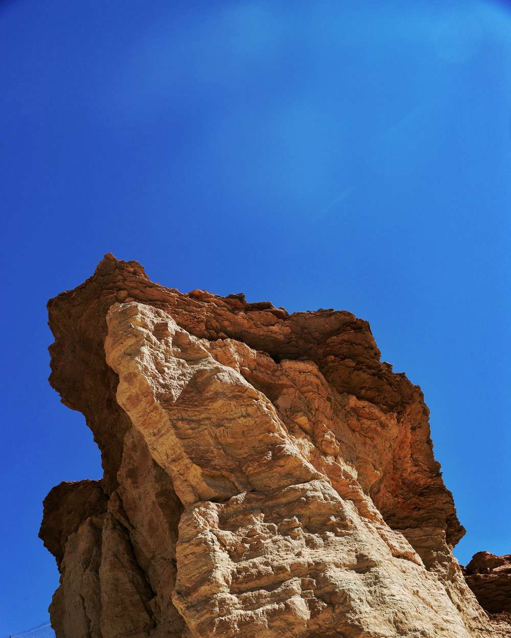 Roca alta de arenisca contra un cielo azul