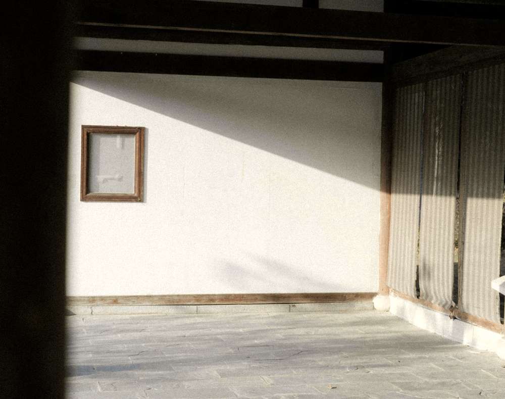 Sala vacía con la luz de una ventana sobre un piso de losas