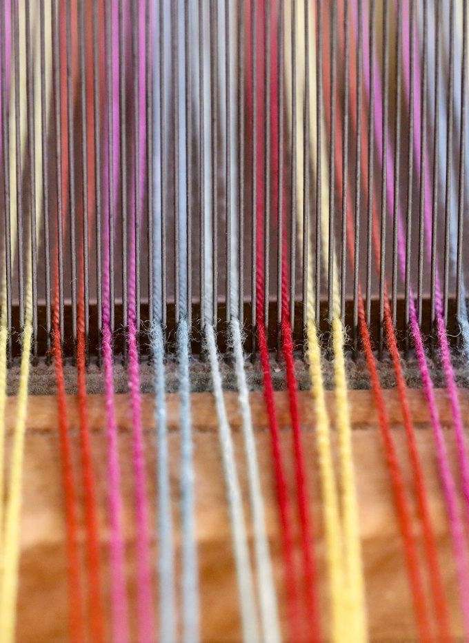 Hilos de colores tensados en un telar