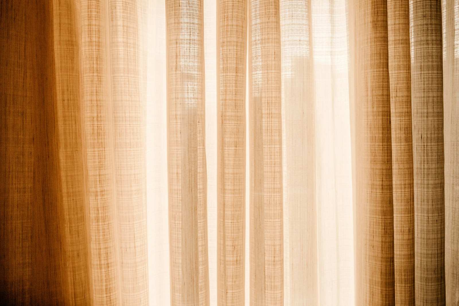 Cortinas de lino en tonos ámbar atravesadas por la luz