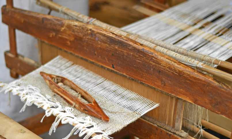 Lanzadera de madera sobre una tela a medio tejer