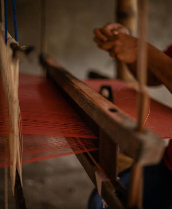 Hilos rojos tensados en un telar antiguo