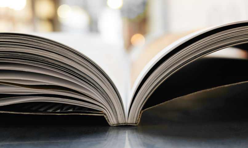 Libro abierto sobre una mesa, con las páginas curvadas