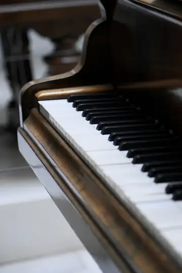 Teclas de un piano de cola con el borde de madera
