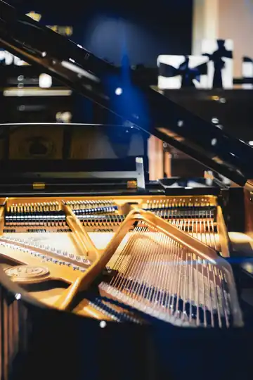 Interior de un piano de cola abierto, con las cuerdas a la vista