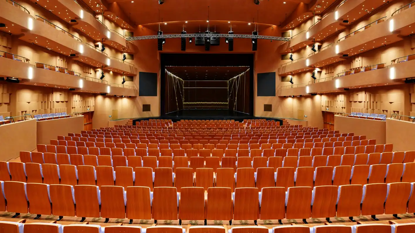Sala de conciertos con butacas naranjas vista desde el fondo